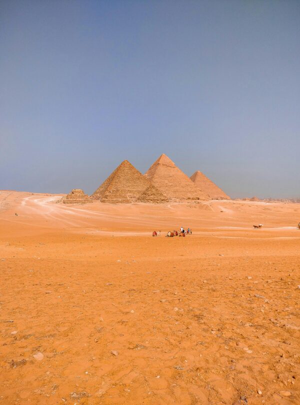 A breathtaking view of the iconic pyramids of Giza standing tall in the Egyptian desert.