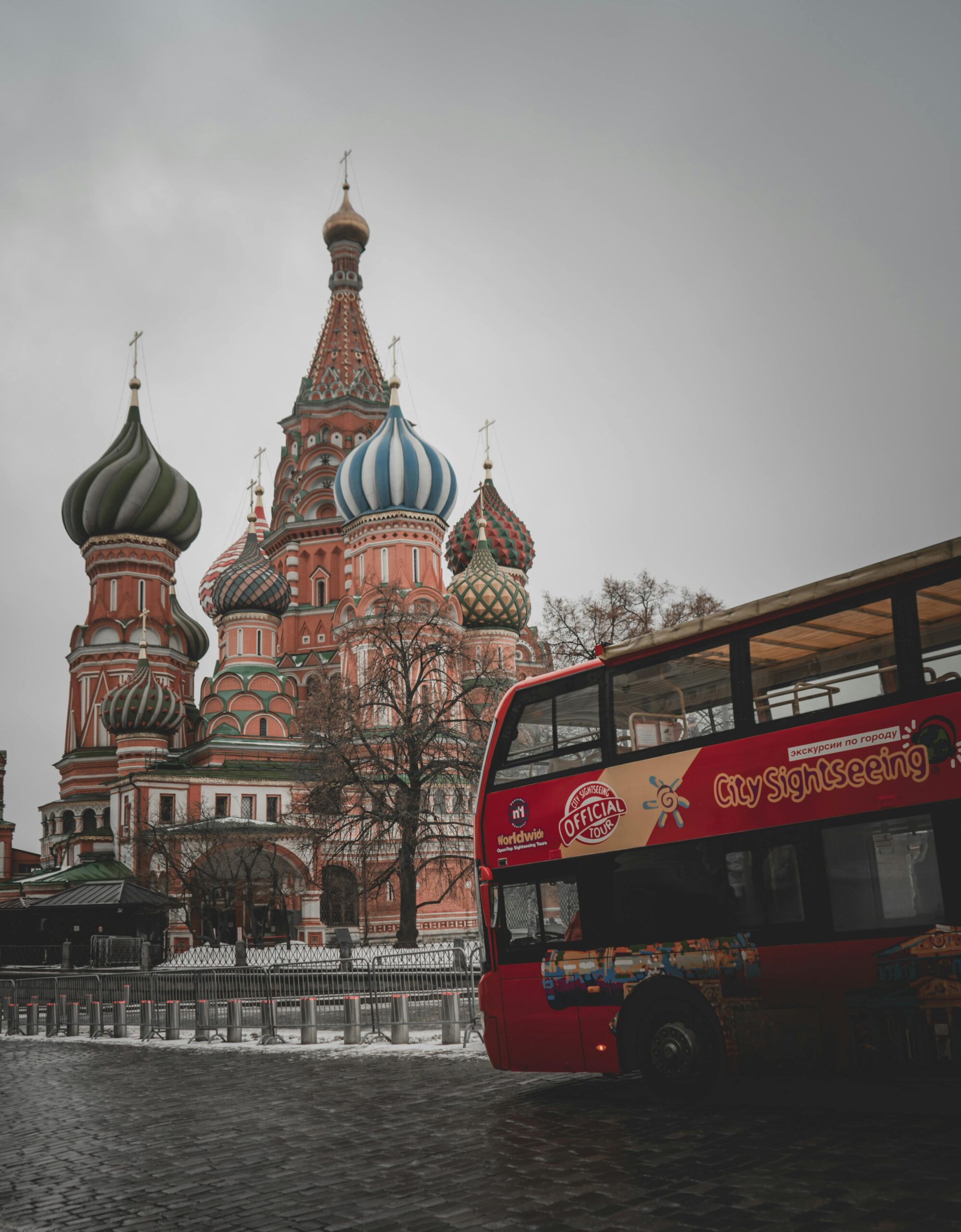 Iconic Saint Basil's Cathedral in Moscow with a red sightseeing bus in winter.